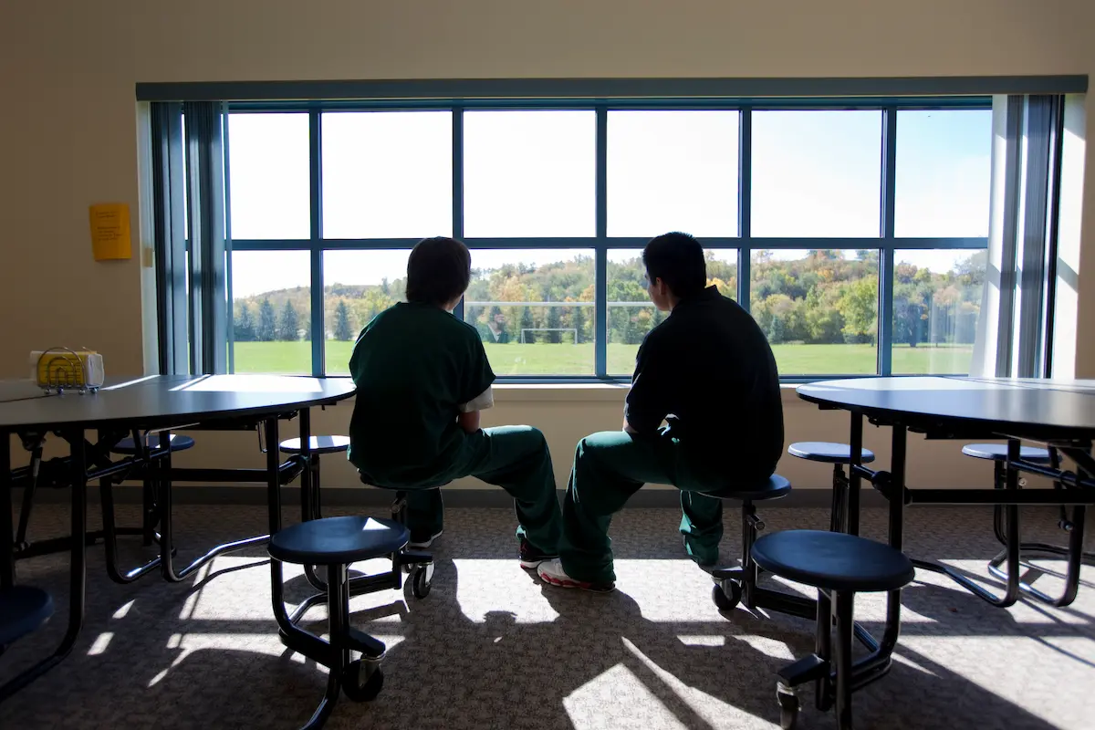 two people watching outside window